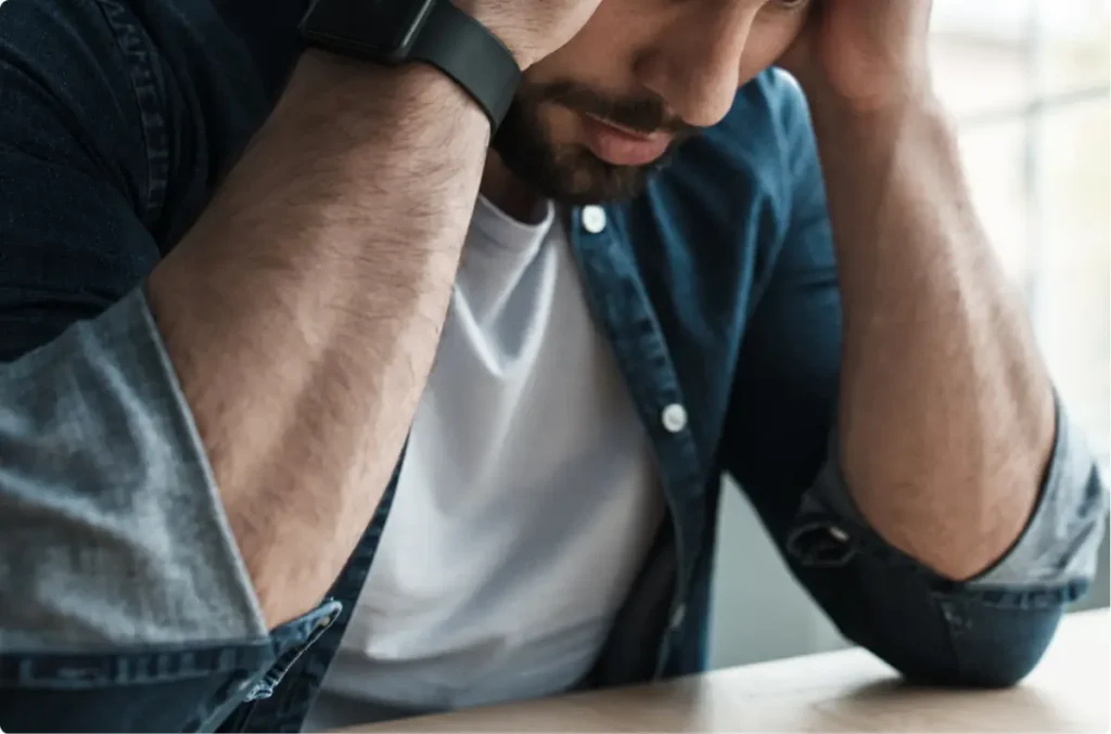 Man experiencing anxiety symptoms while seated alone, representing the emotional impact of anxiety disorders.